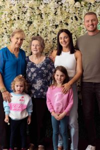 family group posing in front of a floral backdrop