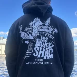 Back view of a person wearing a black hoodie with a white graphic reading 'the Lucky Shag' and 'Perth Western Australia' by the water.
